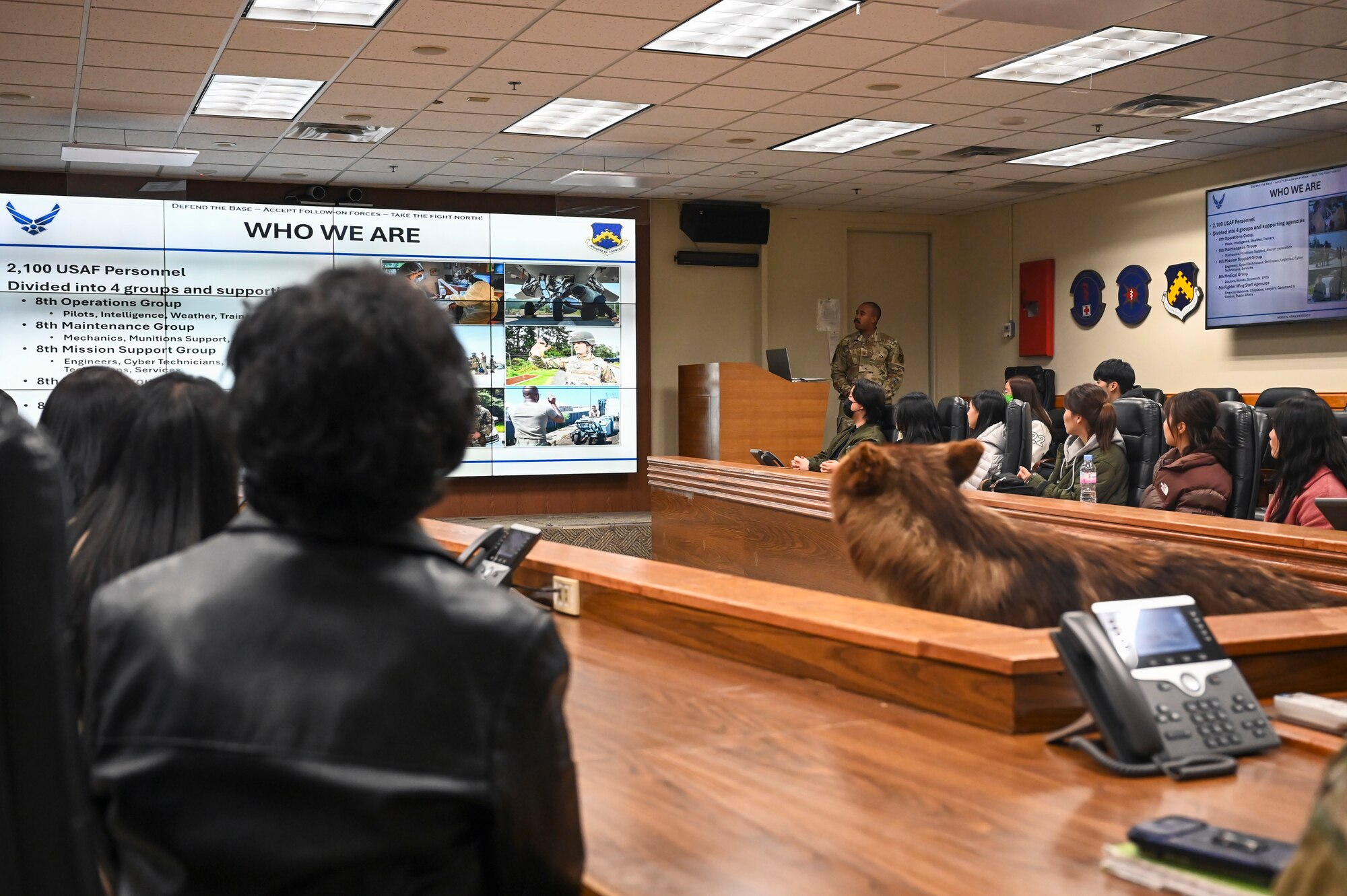 U.S. Air Force Capt. Alvin Nelson, 8th Fighter Wing Public Affairs Officer, briefs students from Kunsan National University about Kunsan Air Base and the 8th FW in the wing conference room.