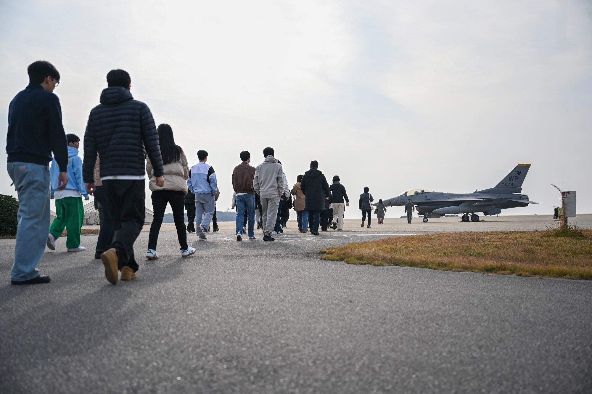 Students for Kunsan National University approach a U.S. Air Force F-16 Fighting Falcon static display.
