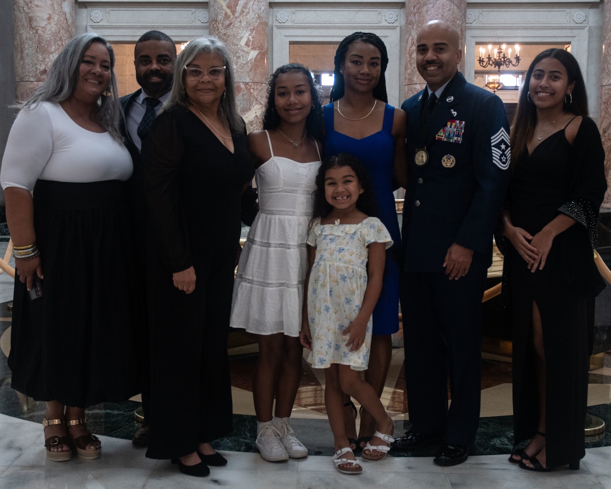 Chief Master Sgt. Israel Nuñez, command chief Air Force Reserve Command and stands for a photo with his family