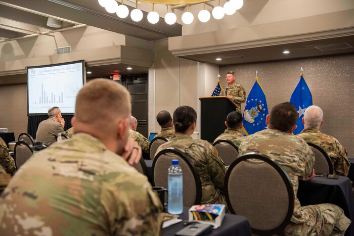 Air Force general officer addressing an audience from a podium at a conference.