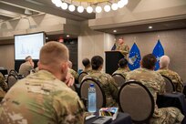 Air Force general officer addressing an audience from a podium at a conference.
