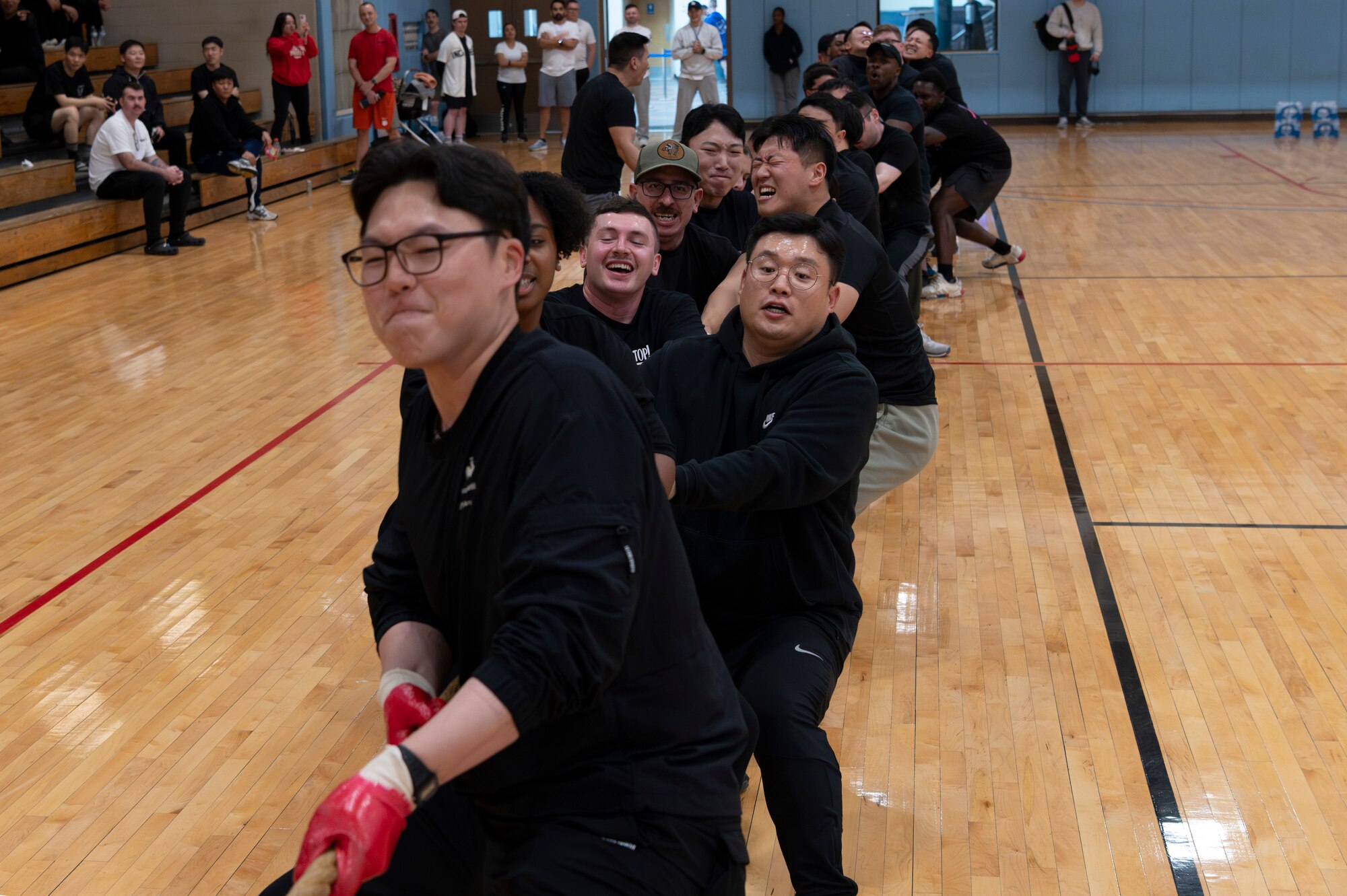 U.S. Air Force members assigned to Osan Air Base and Republic of Korea Air Force members participate in a tug-of-war during a semi-annual  sports day at Osan AB, ROK, Nov. 15, 2024. Members from 17 intelligence units across Osan AB gathered to form four teams and participate in five events including volleyball, dodgeball, basketball, tug-of-war and a relay race. The high turnout, careful planning and camaraderie of these sports days reflect the partnership the intel community shares inside and outside of their work centers. (U.S. Air Force photo by Staff Sgt. Ashley N. Mikaio)