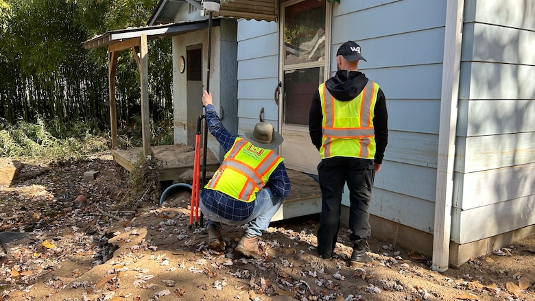Mike Light (Right) and Mark Veasey, members of a U.S. Army Corps of Engineers Nashville District High-Water Marks Team, identifies a mud line Oct. 29, 2024, on a home along the Swannanoa River in Black Mountain, North Carolina. This area flooded during Hurricane Helene. (USACE Photo by Patrick Garner)