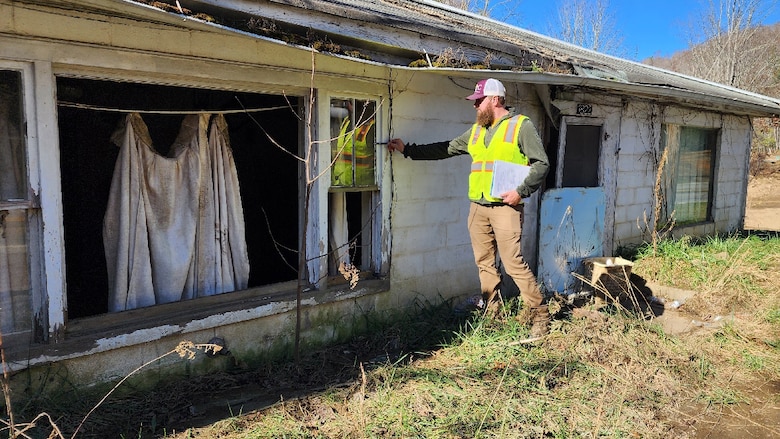 Ryan Wigner measures a high-water mark Nov. 13, 2024, on a building along the North Toe River in Mitchell County, North Carolina. By collecting accurate measurements of Hurricane Helene flood levels and their impact, the Corps of Engineers is building a foundation for more effective planning and response to future weather events. (USACE Photo by Anderson Schmittou)