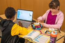 Two students collaborate on programming their robot during the Middle School Innovation Challenge @ Dahlgren, fine-tuning their design to tackle the competition’s missions. (Morgan Tabor/NSWCDD)