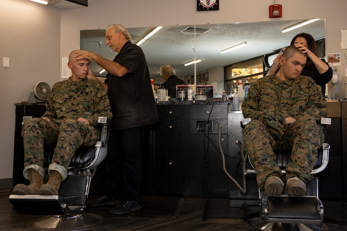 U.S. Marine Corps Recruit Matthew Devoy, left, and Rct. Jesus Alcaraz with Echo Company, 2nd Recruit Training Battalion, receive their weekly haircuts during a post exchange and haircut call at Marine Corps Recruit Depot San Diego, California, Nov. 18, 2024. Recruits are allowed to go to the PX to buy necessary supplies and receive haircuts weekly during their time at MCRD San Diego in order to maintain a uniform appearance and promote good hygiene throughout recruit training. (U.S. Marine Corps photo by Lance Cpl. Janell B. Alvarez)