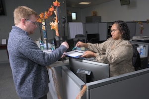 DLA Security Assistant Verifying Official Maria Jones assists a customer inside the McNamara Headquarters Complex Pass and Identification Card at DLA Headquarters in Fort Belvoir, Virginia,