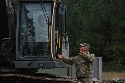 A Citizen Airman assigned to the 910th Civil Engineer Squadron instructs a junior enlisted member on proper operating procedures for heavy machinery at Dobbins Air Reserve Base, Georgia, Nov. 14, 2024.