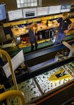 Arianna Kerkmaz and Patrick White, students at the University of Michigan, observe a model of a guided-missile destroyer in “ice” during testing on Dec. 12, 2023, in the university’s tow tank. Kerkmaz is a Naval Engineering Education Consortium (NEEC) student and a former summer intern at Naval Surface Warfare Center, Carderock Division. White, also a NEEC student and a SMART fellow, will work at Carderock after completing his master’s degree.