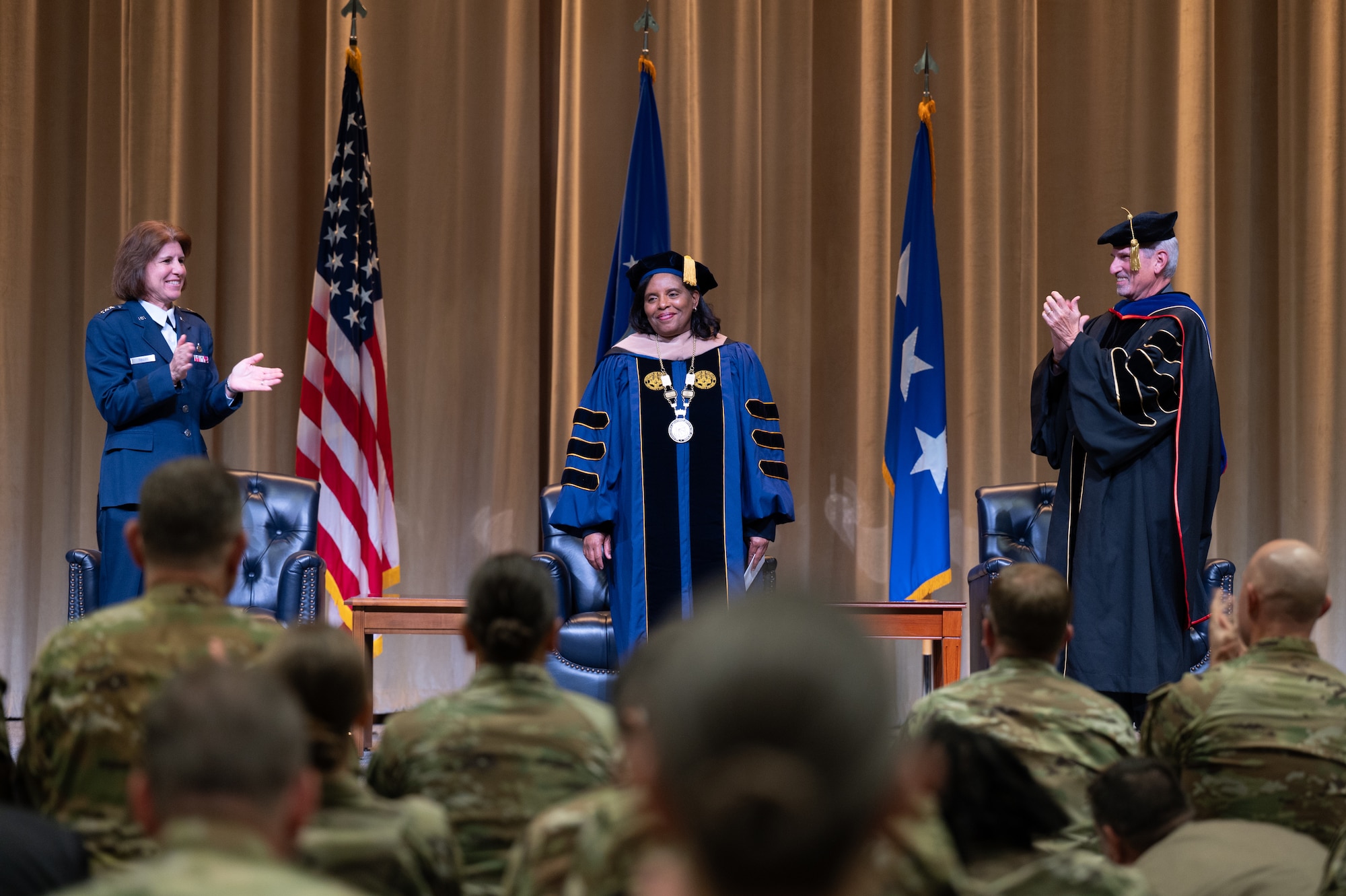 U.S. Air Force Lt. Gen. Andrea Tullos, Air University commander and president, Dr. Yolanda Williams, provost and chief academic officer of Air University and Dr. Mark Conversino, former provost and chief academic officer of Air University, stand on stage during an acceptance of leadership ceremony at Maxwell Air force Base, Alabama, Nov. 22, 2024. The Chief Academic Officer’s role is to act as the principal authority and executive-level advisor to the Air University commander and president for all issues concerning the academic programs across the university. (U.S. Air Force photo by Senior Airman Evan Porter)