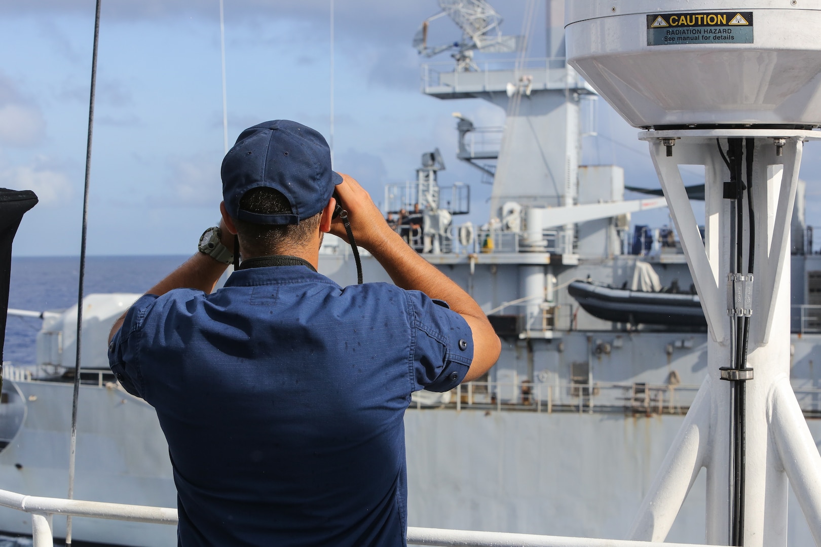 Seaman Carlos Ortega-Acevedo, a crew member assigned to U.S. Coast Guard Cutter Valiant (WMEC 621), performs the role of lookout while the cutter conducts at-sea exercises with French Navy Frigate FS Ventôse (F733), Sept. 29, 2024, while underway in the Windward Passage. The crew of Valiant conducted a 49-day migrant interdiction operations patrol in the region to protect life at sea and enforce U.S. maritime law. (U.S. Coast Guard photo by Seaman Reese Fishbaugh)