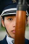 Portrait photo of a U.S. Air Force Honor Guardsman holding a ceremonial rifle at port arms.
