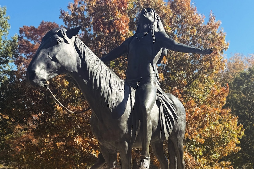 A statue of a Native American riding a horse.