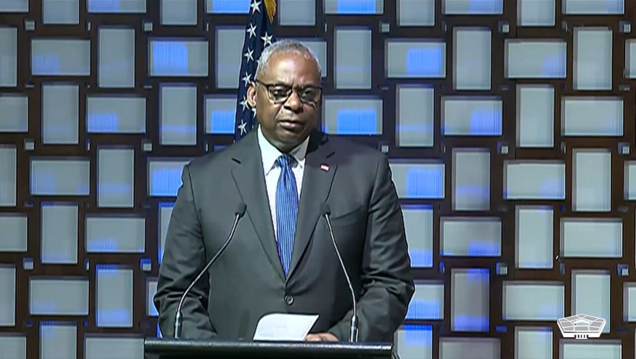 A government official speaks from a podium.