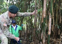 U.S. Army Garrison Japan Commander Col. Marcus Hunter cuts bamboo with a member of the Sagami Giant Kite Preservation Association, Kassaka District, Nov. 15 on Camp Zama.