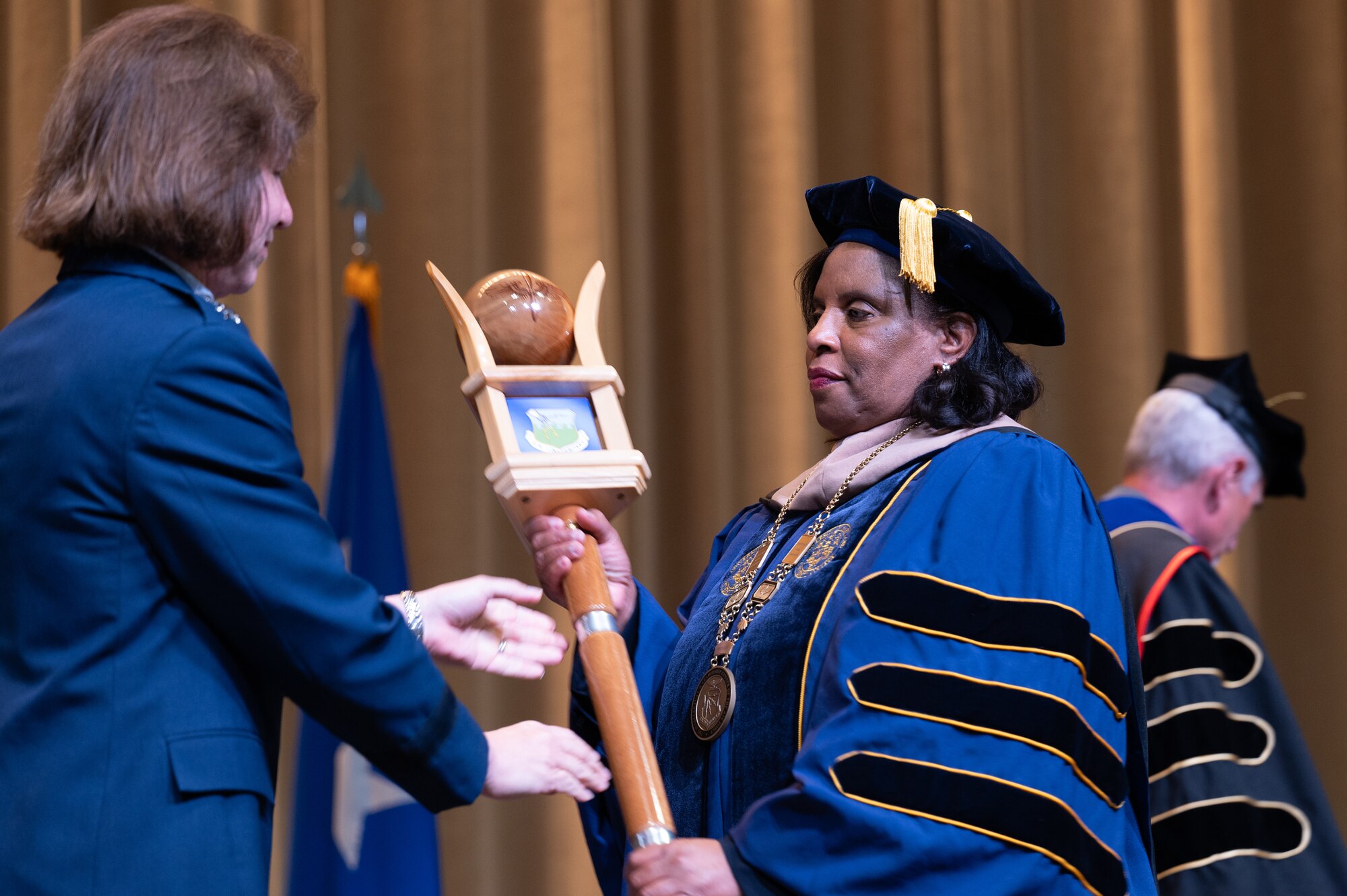 Dr. Yolanda Williams, provost and chief academic officer of Air University, recieves the University Mace from U.S. Air force Lt. Gen. Andrea Tullos, Air University commander and president, during a acceptance of leadership ceremony at Maxwell Air force Base, Alabama, Nov. 22, 2024. Williams will oversee curriculum development, accreditation compliance, institutional research, and coordination with Air Force headquarters and university leaders to ensure program quality. (U.S. Air Force photo by Senior Airman Evan Porter)