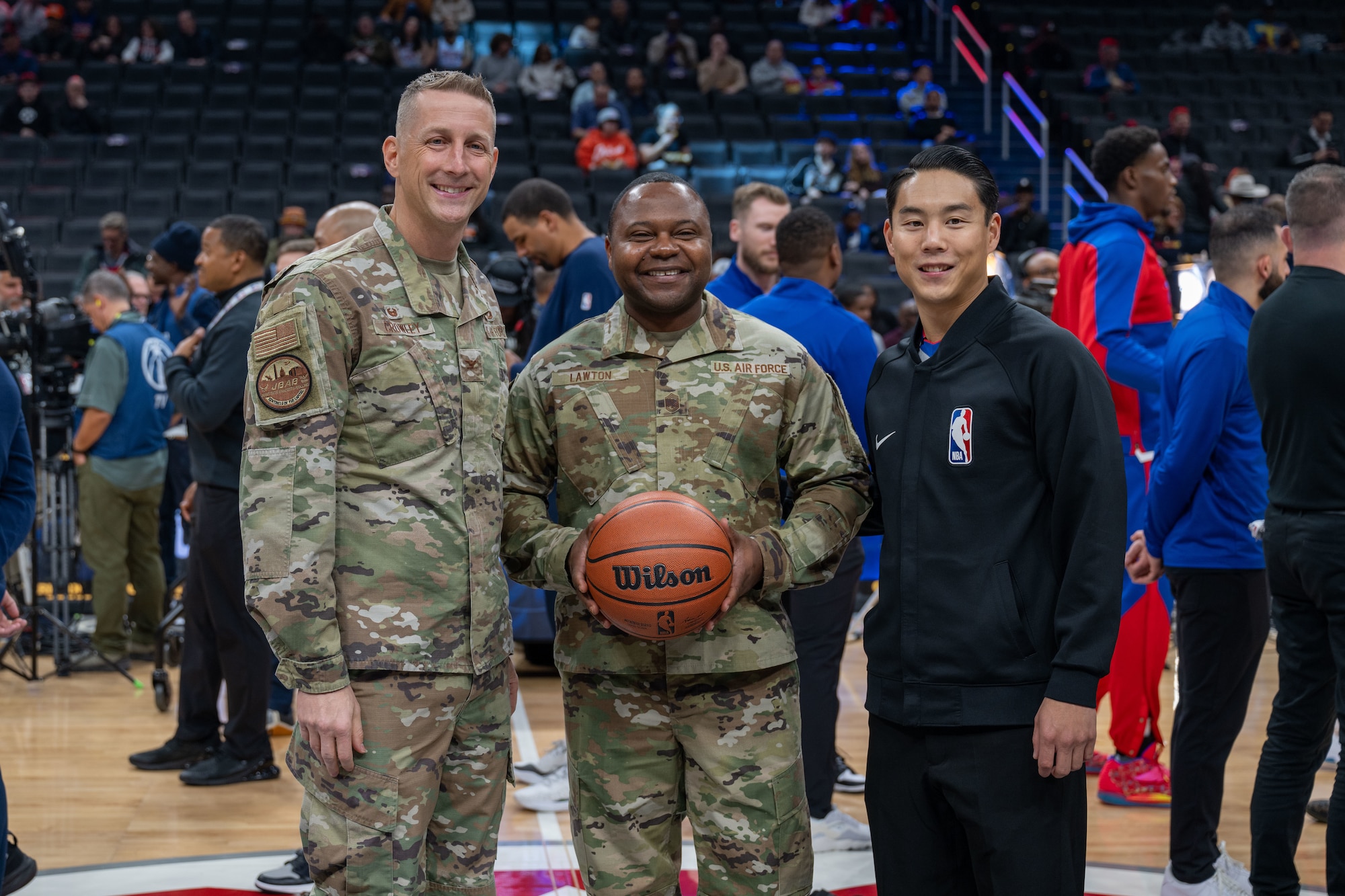 Men stand together holding a basketball