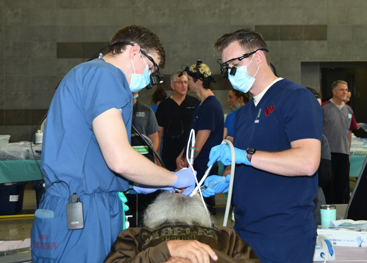 2 dentists operating on a patient