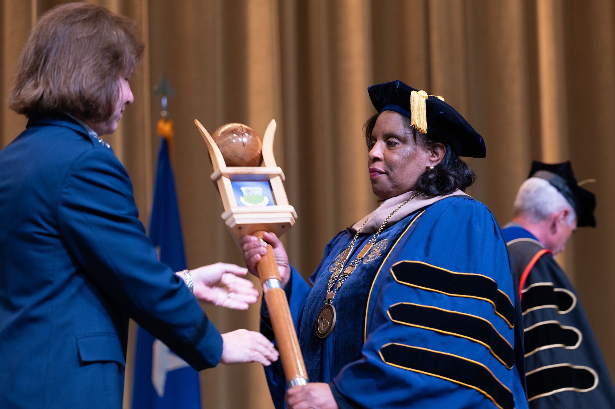 Dr. Yolanda Williams, provost and chief academic officer of Air University, recieves the University Mace from U.S. Air force Lt. Gen. Andrea Tullos, Air University commander and president, during a acceptance of leadership ceremony at Maxwell Air force Base, Alabama, Nov. 22, 2024. Williams will oversee curriculum development, accreditation compliance, institutional research, and coordination with Air Force headquarters and university leaders to ensure program quality. (U.S. Air Force photo by Senior Airman Evan Porter)