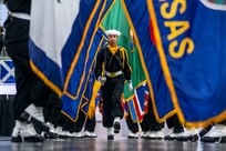 Performance division recruits carrying state flags march on the drill deck during Recruit Training Command's pass in review graduation at Naval Station Great Lakes.