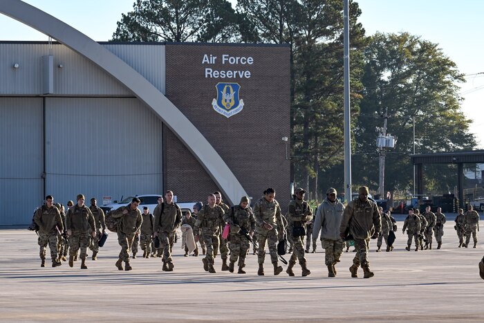 Citizen Airmen assigned to the 910th Airlift Wing walk toward a C-130J-30 Super Hercules to travel back to Ohio on the flightline at Dobbins Air Reserve Base, Georgia, Nov. 16, 2024.