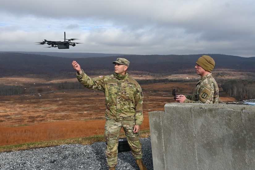 Staff Sgt. Luis Andujar, left, prepares to catch a drone piloted by Sgt. 1st Class Richard Hutnik, right, Nov. 15, 2024, at Fort Indiantown Gap, Pa. Andujar and Hutnik, both with 1st Battalion, 166th Regiment - Regional Training Institute were using drones to collect targeting data that was used to submit a call for fire to instructors and students with 2nd Battalion, who engaged the targets with artillery fire using M119, M777, and M109A6 howitzers. (Pennsylvania National Guard photo by Brad Rhen)