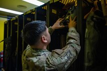 An Airman inspects a pilot's helmet