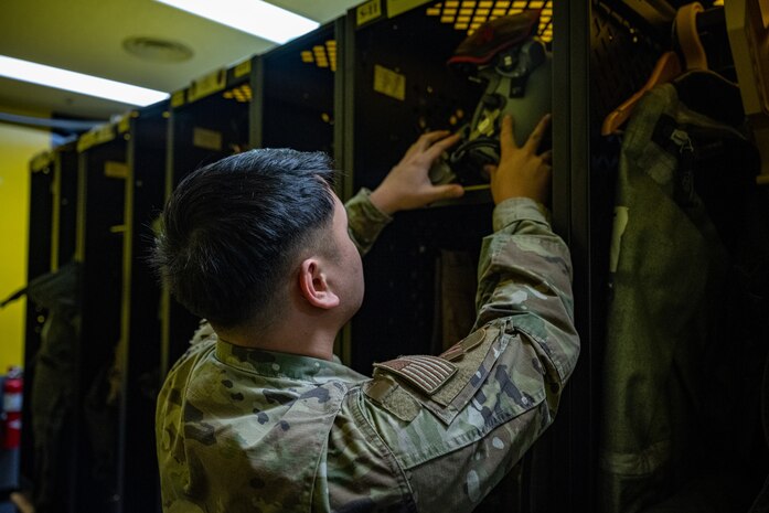 An Airman inspects a pilot's helmet