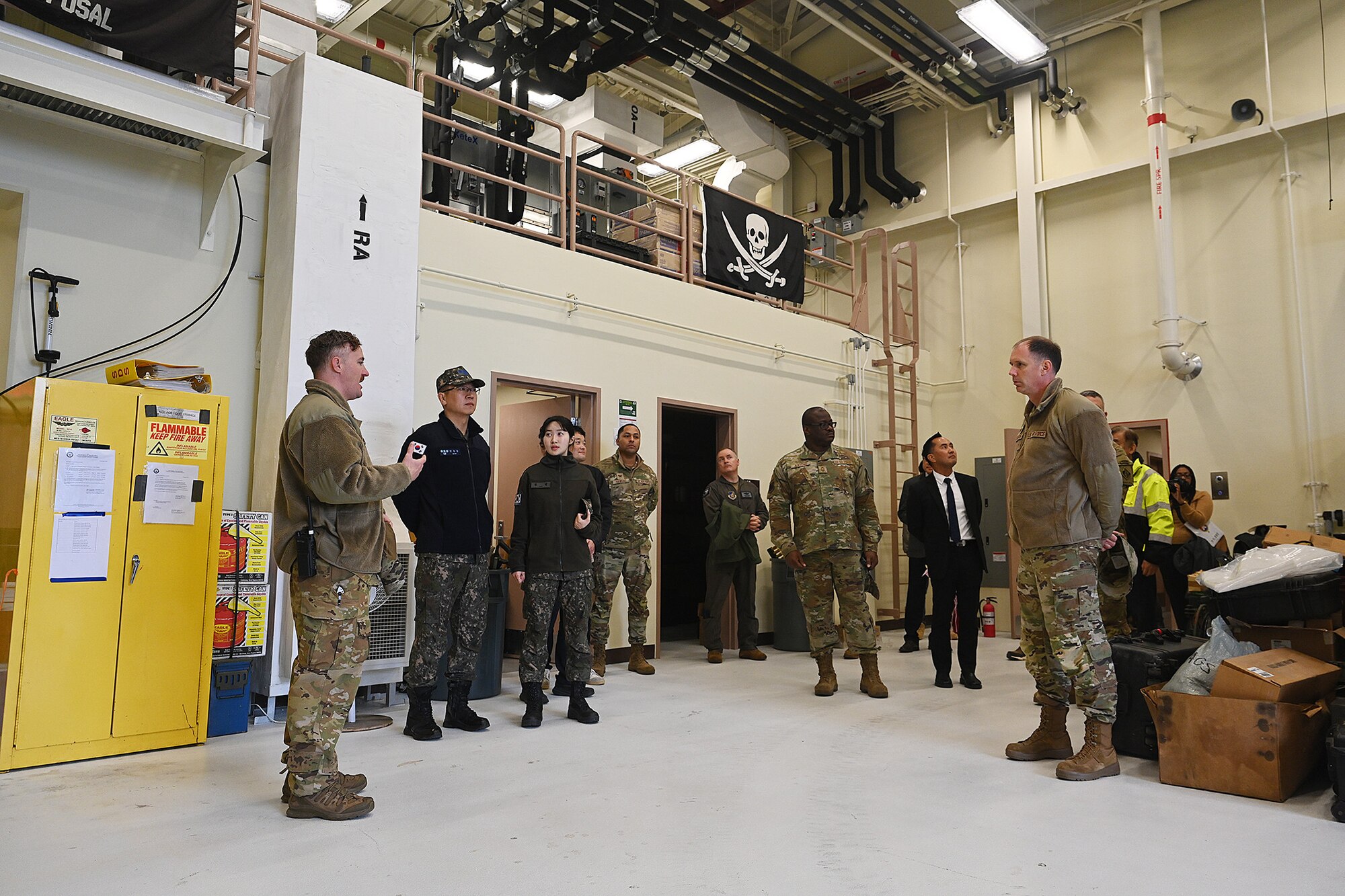 U.S. Air Force Master Sgt. Leland Mello, left, 8th Civil Engineer Squadron explosive ordnance disposal superintendent, briefs base leadership, host nation military and civilian partners during the explosive ordnance disposal ribbon-cutting ceremony tour.