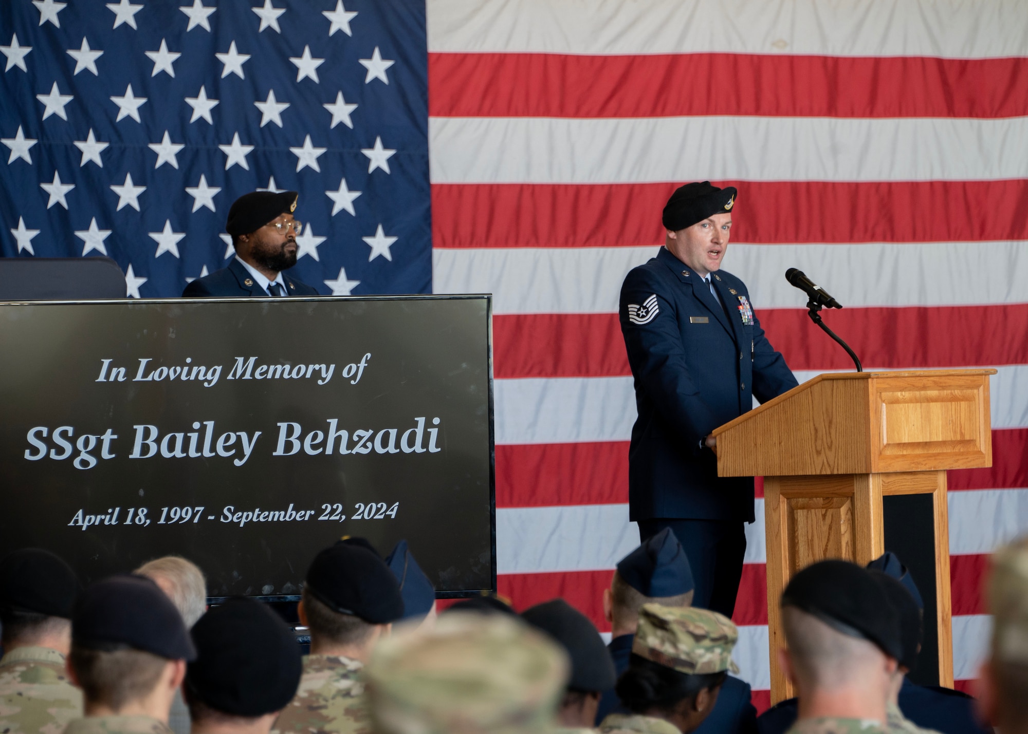 U.S. Air Force Tech. Sgt. Justin Butler, 316th Security Forces Squadron flight sergeant, addresses the audience during the memorial service for Staff Sgt. Bailey Behzadi at Joint Base Andrews, Oct. 21, 2024. As Behzadi’s supervisor, Butler shared personal memories and paid tribute to Behzadi’s dedication and impact on those around him. (U.S. Air Force photo by Staff Sgt. Aubree Owens)