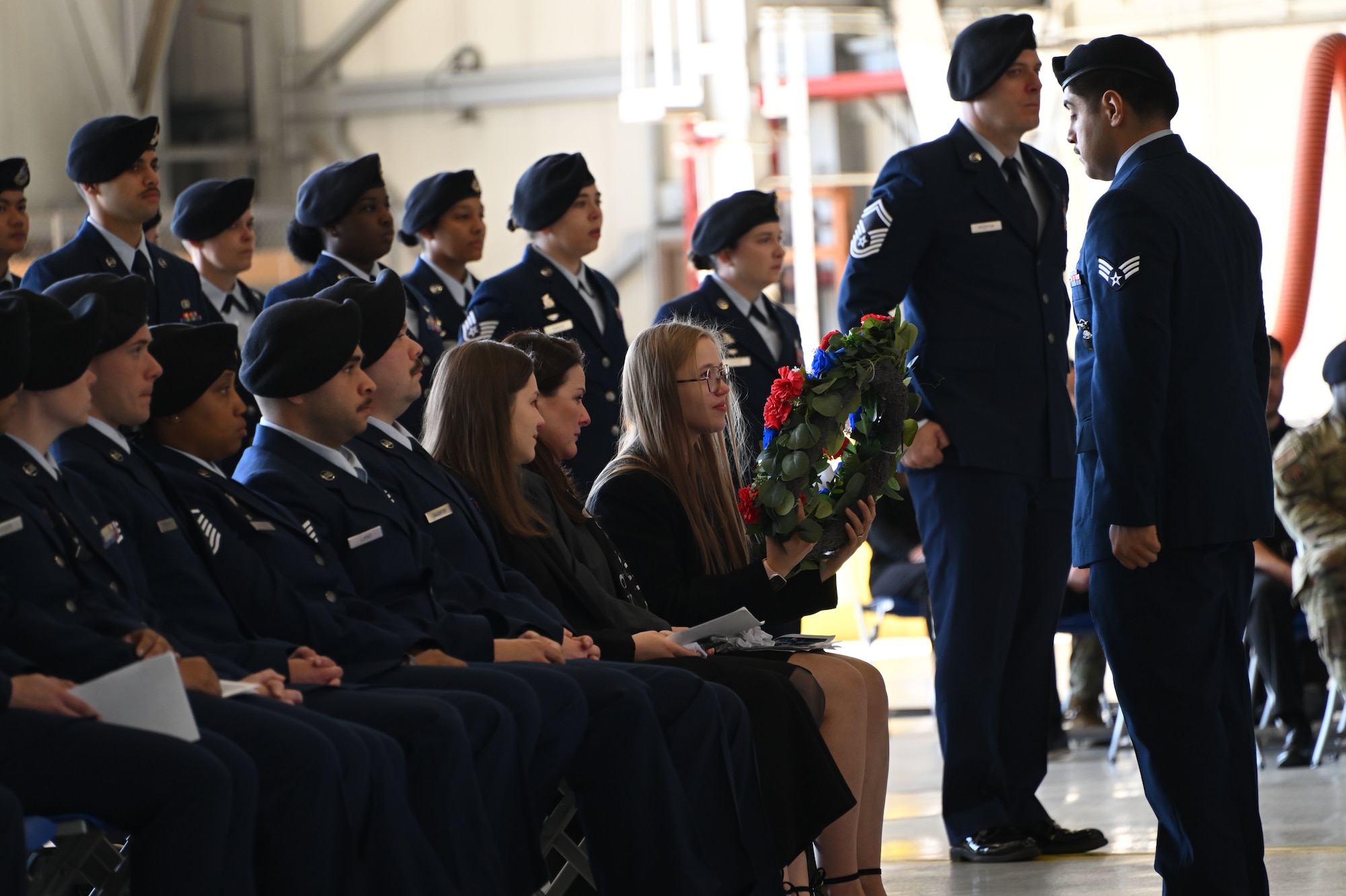 Luiza Behzadi receives a wreath in honor of her husband, Staff Sgt. Bailey Behzadi, during his memorial service at Joint Base Andrews, Md., Oct. 21, 2024. The wreath commemorated Behzadi’s service to the Air Force and his country. (U.S. Air Force photo by Airman 1st Class Gianluca Ciccopiedi)