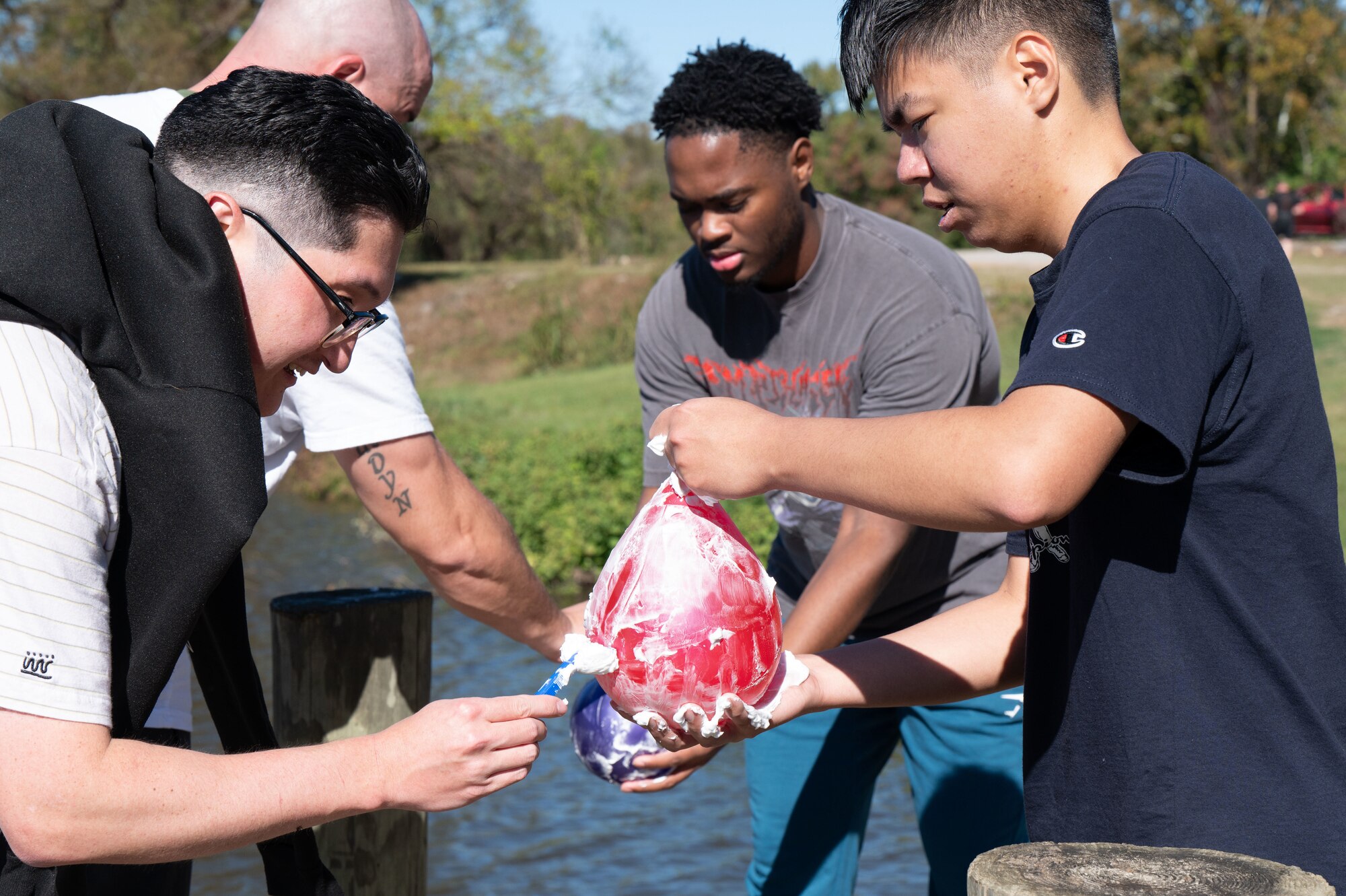 U.S. Airmen participate in a balloon-shaving team challenge at Maxwell Air Force Base, Ala, Nov. 21, 2024. GRIT Week is an annual, week-long event featuring a variety of activities to foster resilience and teamwork.