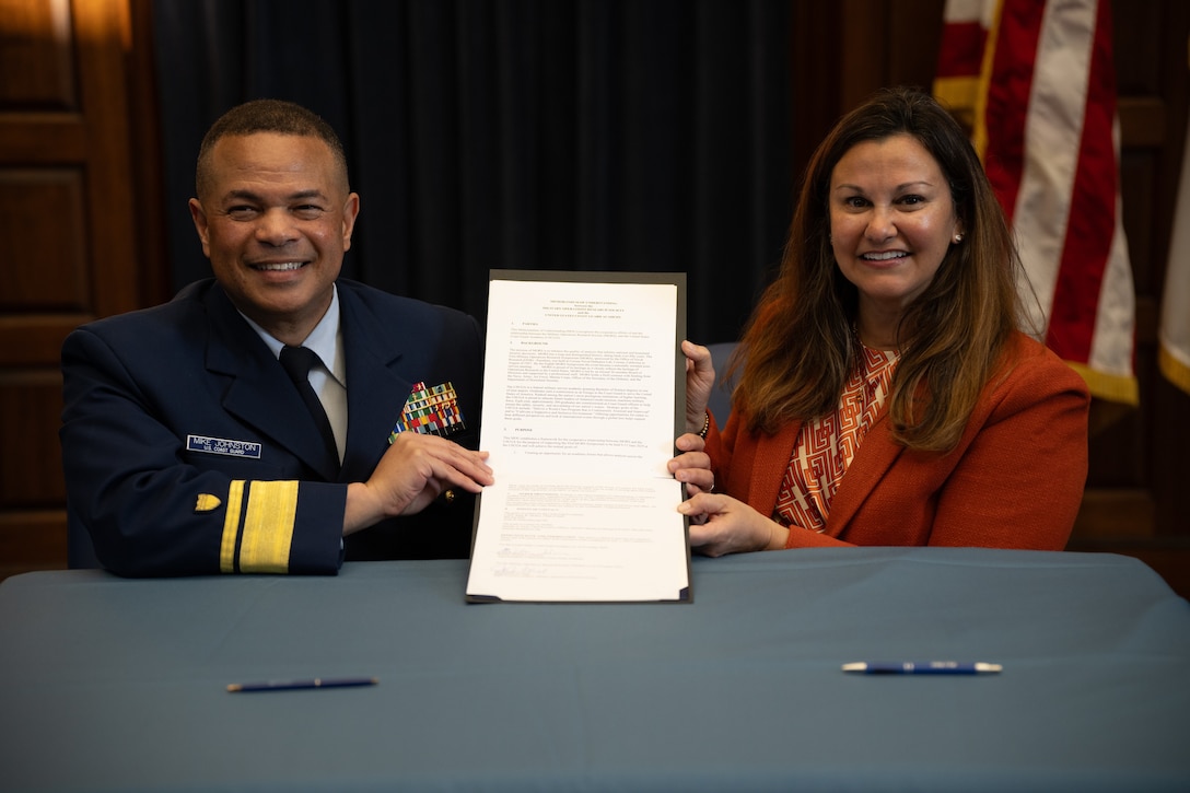 U.S. Coast Guard Rear Adm. Mike Johnston, Superintendent of the U.S. Coast Guard Academy, and Jennifer Ferat sign an agreement as part of the Academy’s role in hosting the Military Operations Research Society (MORS) 93rd Symposium, Nov 18, 2024. Approximately 1,000 defense experts from government, academia, and industry will gather to address critical national security challenges. (U.S. Coast Guard photo by Petty Officer 3rd Class Matt Thieme)