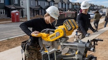 U.S. Marine Corps Staff Sgt. Christa Brown, staff noncommissioned officer of Recruiting Sub-Station Fort Collins, and Staff Sgt. Brandon Michauld, a recruiter with Recruiting Sub-Staton Fort Collins, trim lumber in Greeley, Colo., Nov. 15, 2024. Marines with RSS Fort Collins volunteered with Habitat for Humanity to help build homes, showcasing their dedication to giving back and supporting the local community. (U.S. Marine Corps photo by Sgt. Jackson Ricker)