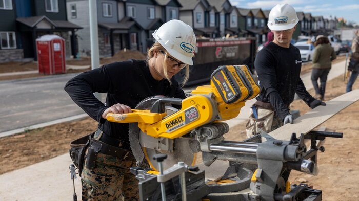 U.S. Marine Corps Staff Sgt. Christa Brown, staff noncommissioned officer of Recruiting Sub-Station Fort Collins, and Staff Sgt. Brandon Michauld, a recruiter with Recruiting Sub-Staton Fort Collins, trim lumber in Greeley, Colo., Nov. 15, 2024. Marines with RSS Fort Collins volunteered with Habitat for Humanity to help build homes, showcasing their dedication to giving back and supporting the local community. (U.S. Marine Corps photo by Sgt. Jackson Ricker)