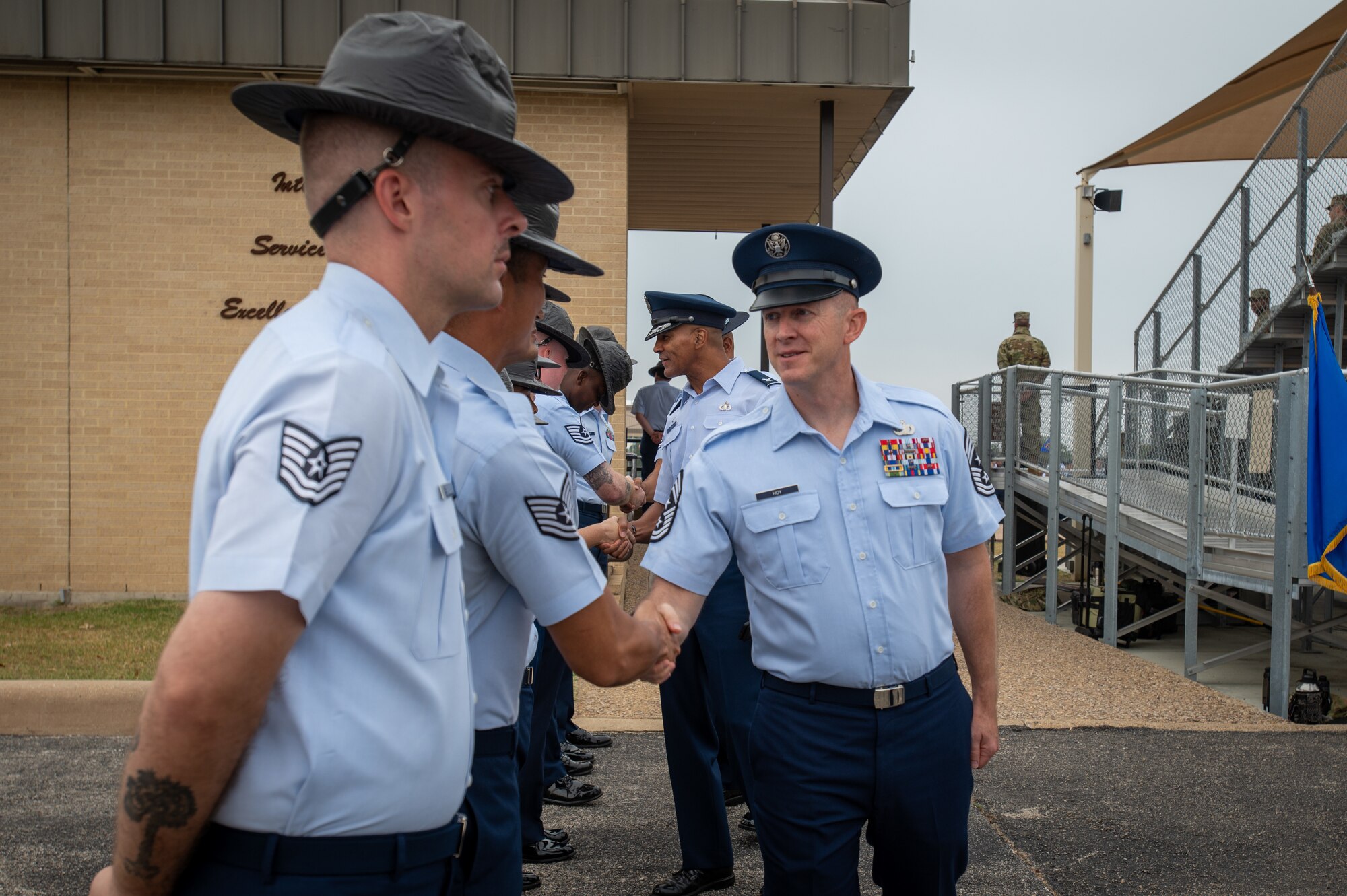 Chief Master Sgt. James Hoy, AFOSI command chief, shakes hands with Military Training Instructors following a Basic Military Training graduation at Joint Base San Antonio-Lackland, Texas, Nov. 7, 2024. Hoy, alongside Brig. Gen. Amy Bumgarner, AFOSI Commander, played a key role in the ceremony. (U.S. Air Force photo by Thomas Brading)