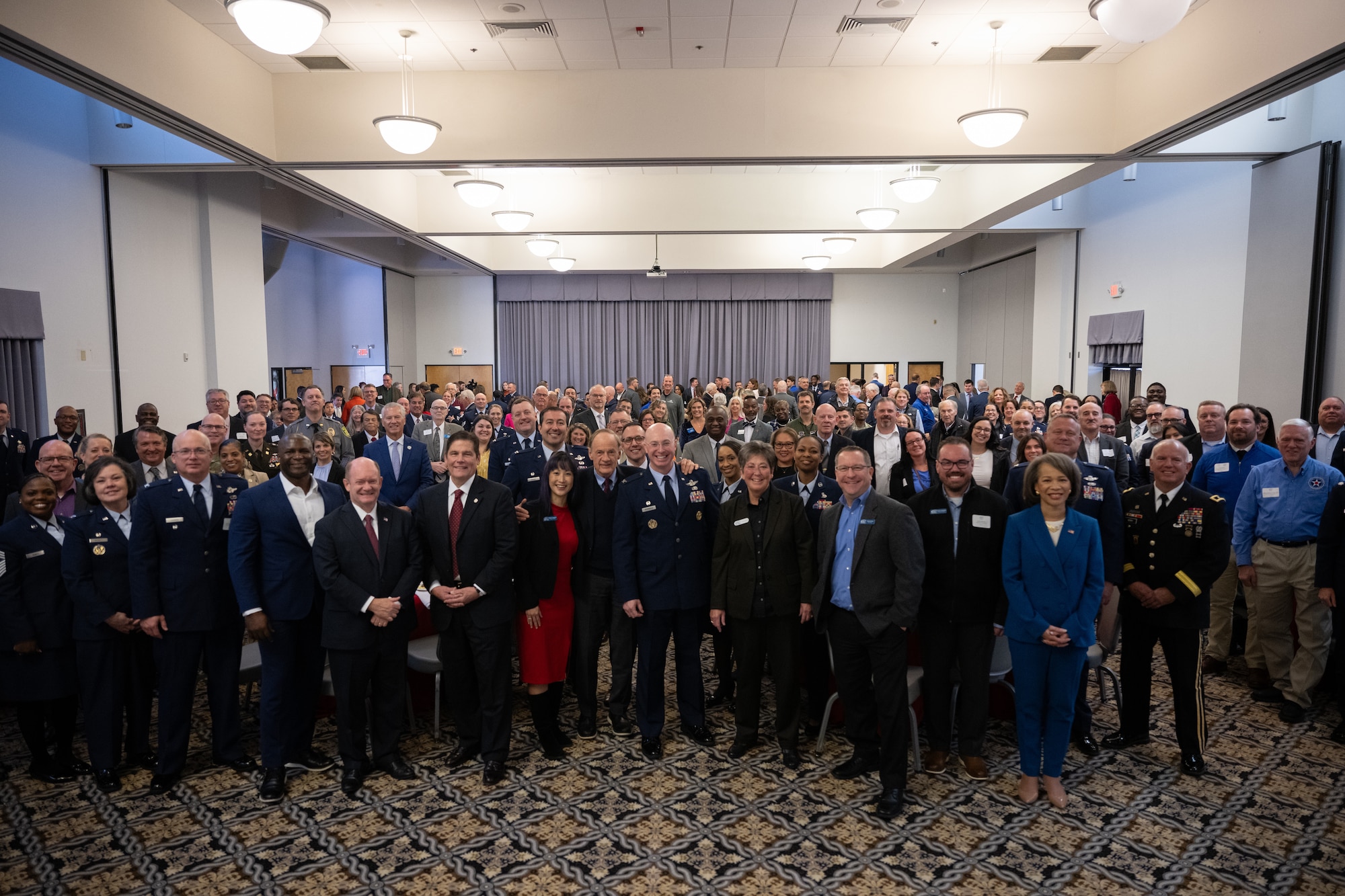 Team Dover members stand with U.S. congressional delegates from Delaware and Central Delaware Chamber of Commerce members, at the 2024 State of the Base briefing on Dover Air Force Base, Delaware, Nov. 25, 2024. The event, hosted by the Central Delaware Chamber of Commerce, provided an opportunity to highlight the accomplishments of Team Dover Airmen and show how the Dover community ties into the base's mission, vision and priorities. (U.S. Air Force photo by Airman 1st Class Liberty Matthews)