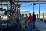 Several people watch demonstration of truck rack operations.
