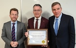 Dr. Timothy Sands, Virginia Polytechnic Institute and State University president, holds the Jack Donnelly Award for Excellence in Counterintelligence after David Cattler, Defense Counterintelligence and Security Agency director, presented the award to Sands, who accepted it on behalf of the university. The award - presented only to entities cleared by the federal government to deter, detect and disrupt the theft of classified information - recognized Virginia Tech for being a national leader in counterintelligence. The ceremony featured remarks by Cattler, Sands and Sen. Mark Warner, D-Va., (standing left to right) regarding the university's counterintelligence accomplishments impacting Virginia Tech’s operations, investigations, cybersecurity, collaboration, community outreach, threat Integration, training and awareness, and leadership.