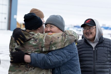 Alaska Army National Guard Chief Warrant Officer 2 Morgan Osborn, left, a UH-60L Black Hawk pilot with the 207th Aviation Troop Command, greets local resident Nick Therchik after delivering thousands of pounds of frozen meat during an Innovative Readiness Training mission at Toksook Bay, Alaska, Nov. 18, 2024.