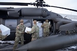 Alaska Army National Guardsmen from the 207th Aviation Troop Command and Bison Company, 1st Battalion, 297th Infantry Regiment, load frozen meat for transport via UH-60L Black Hawk helicopter during an Innovative Readiness Training mission at the AKARNG hangar in Bethel, Alaska, Nov. 18, 2024. Two years ago, the community of Toksook Bay, whose population is almost entirely members of the Alaska Native Nunakauyarmiut Tribe living a subsistence lifestyle, lost thousands of pounds of meat that spoiled due to extended power outages caused by Typhoon Merbok flooding.