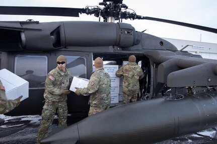 Alaska Army National Guardsmen from the 207th Aviation Troop Command and Bison Company, 1st Battalion, 297th Infantry Regiment, load frozen meat for transport via UH-60L Black Hawk helicopter during an Innovative Readiness Training mission at the AKARNG hangar in Bethel, Alaska, Nov. 18, 2024. Two years ago, the community of Toksook Bay, whose population is almost entirely members of the Alaska Native Nunakauyarmiut Tribe living a subsistence lifestyle, lost thousands of pounds of meat that spoiled due to extended power outages caused by Typhoon Merbok flooding.