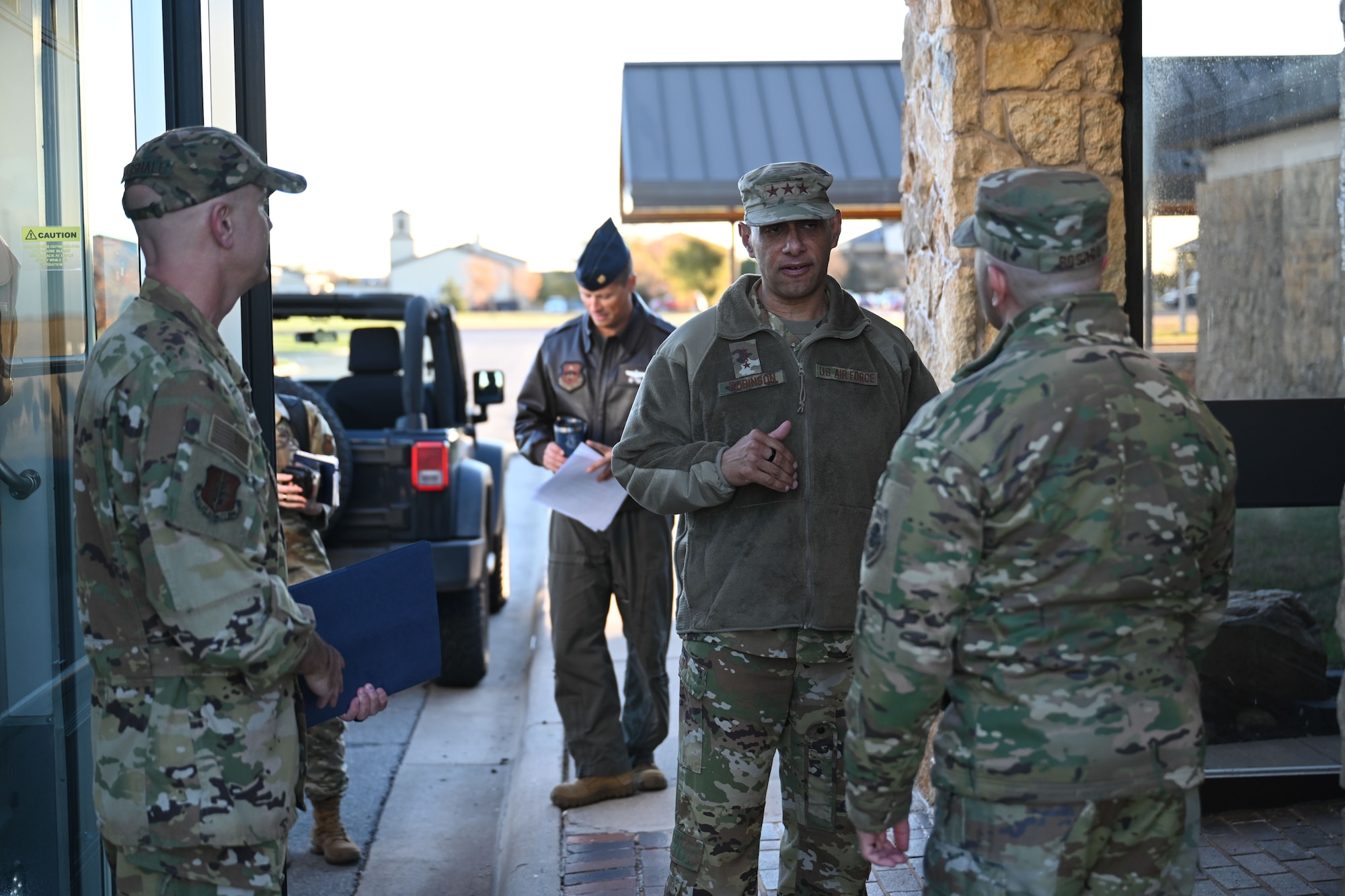 U.S. Air Force Lt. Gen. Brian S. Robinson, commander of the Air Education and Training Command (AETC), greets Col. Jeff Marshall, 97th Air Mobility Wing (AMW) commander, left, and Col. Adam Rosado, 97 AMW deputy commander, at Altus Air Force Base, Oklahoma, Nov. 20, 2024. AETC operates 12 major installations and supports tenant units on numerous bases across the globe. (U.S. Air Force photo by Airman 1st Class Jonah Bliss)