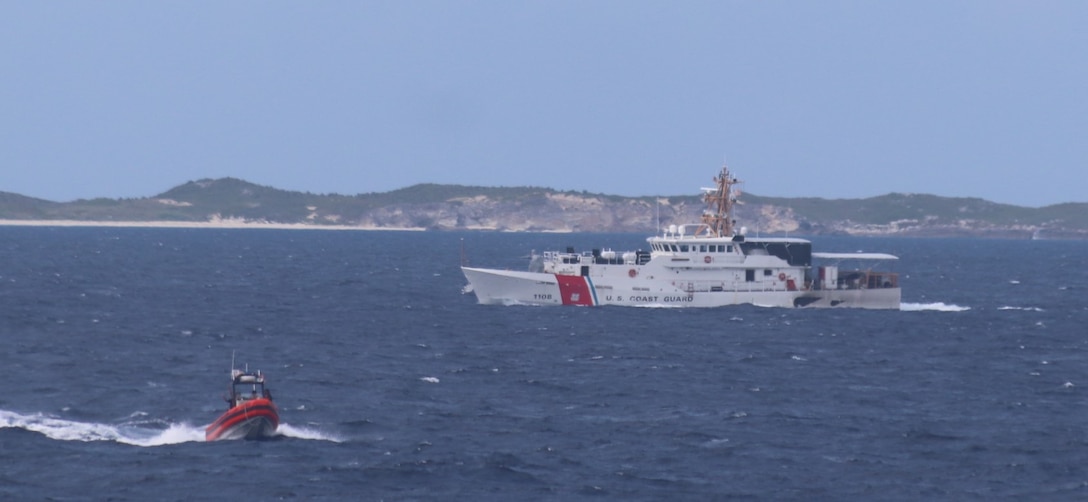 Coast Guard Cutter Charles Sexton (WPC 1108), background, assists Coast Guard Cutter Vigilant (WMEC 617) with the rescue of 22 migrants, Oct. 8, 2024, who were stranded on a remote Bahamian island. Vigilant's crew conducted a 54-day patrol in the Florida Straits and Caribbean Sea. (U.S. Coast Guard photo by Petty Officer 2nd Class Evan Tellado.)