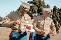 The Commanding Officer of Headquarters and Service Battalion, Marine Corps Recruit Depot San Diego, U.S. Marine Corps Col. Jason Freeby, right, presents a slice of cake to the oldest Marine present, The Assistant Chief of Staff, Depot Inspector of Headquarters and Service Battalion, Col. David Arenas, during a cake cutting ceremony at MCRD San Diego California, Nov. 6, 2024.  Arenas enlisted February of 1992 and commissioned in April of 2000. The annual cake cutting ceremony is a long-standing tradition that celebrates the establishment of the United States Marine Corps. The Marine Corps birthday, on Nov. 10, 1775, is celebrated every year to commemorate the birth of the Corps and honor the service of all Marines, past and present. (U.S. Marine Corps photo by Cpl. Sarah M. Grawcock)