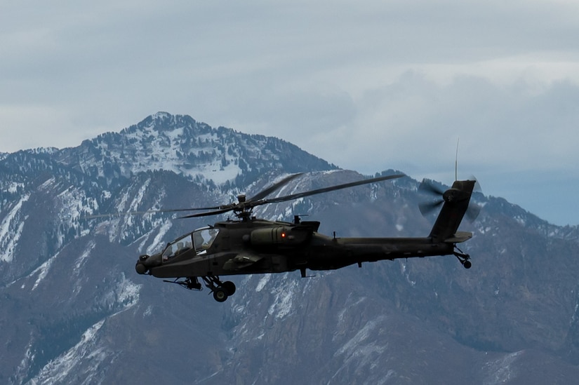 A helicopter flies past a snowy mountain