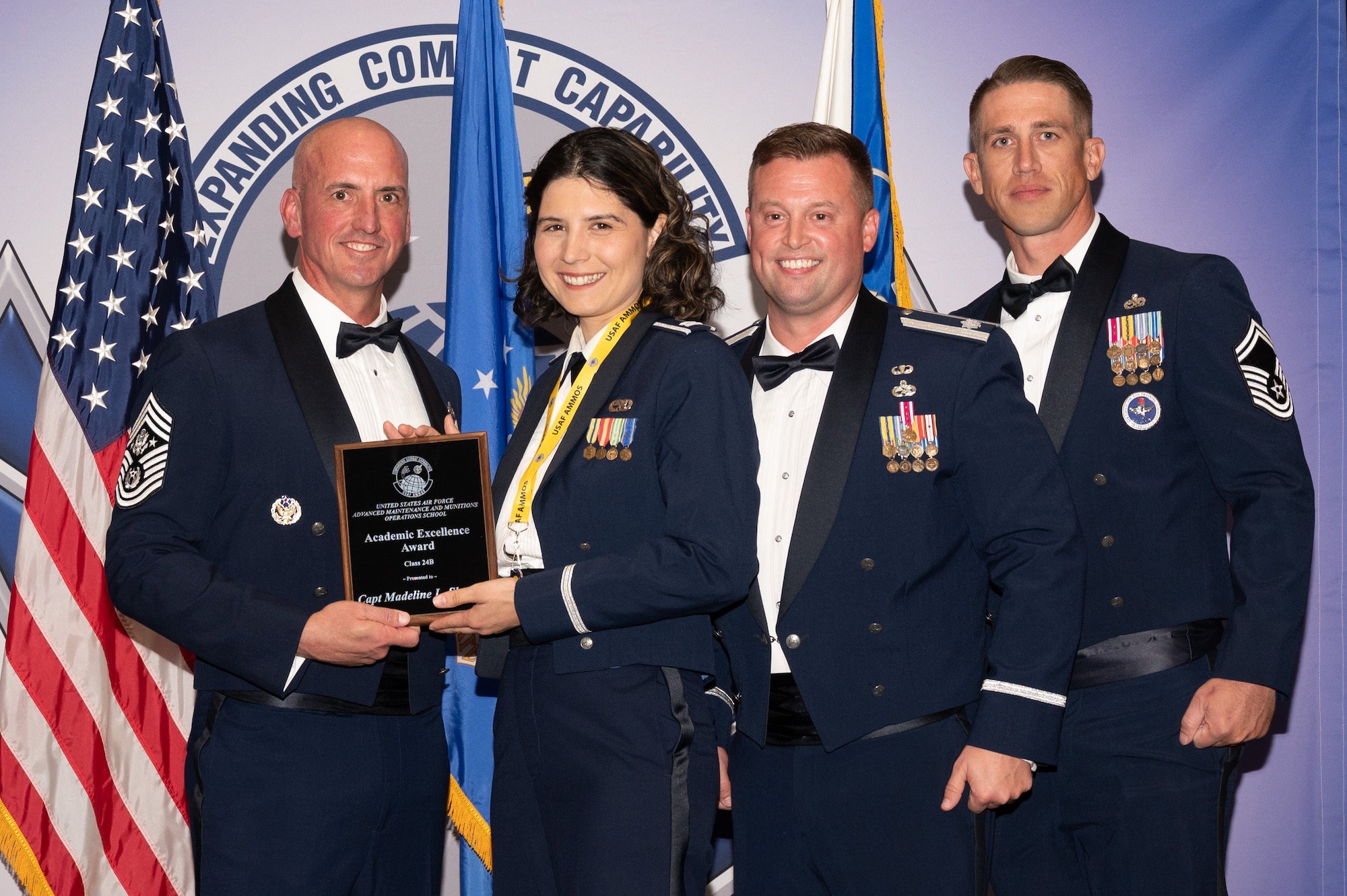 Four people posing with award