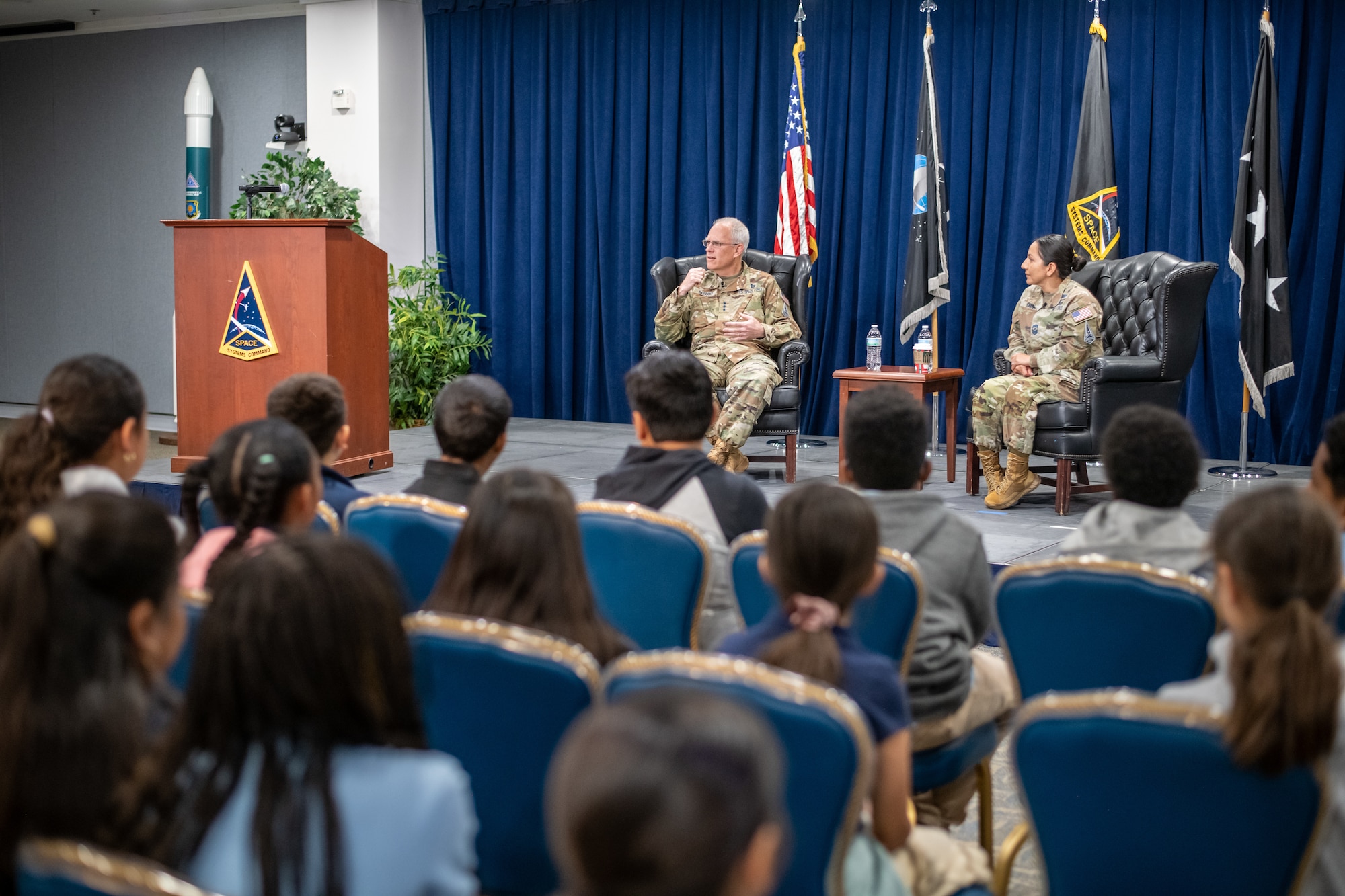 USSF Lt. Gen. Philip Garrant, commander, Space Systems Command, and Chief Master Sgt. Jacqueline Sauvé, senior enlisted leader, SSC, participate in a Q&A session with fifth grade students from Ramona Elementary in Hawthorne, Calif. on Nov. 12, 2024, at Los Angeles Air Force Base. Students eagerly asked questions about what the Space Force does and what they can do to become Guardians when they grow up.  (U.S. Space Force photo by Van Ha)
