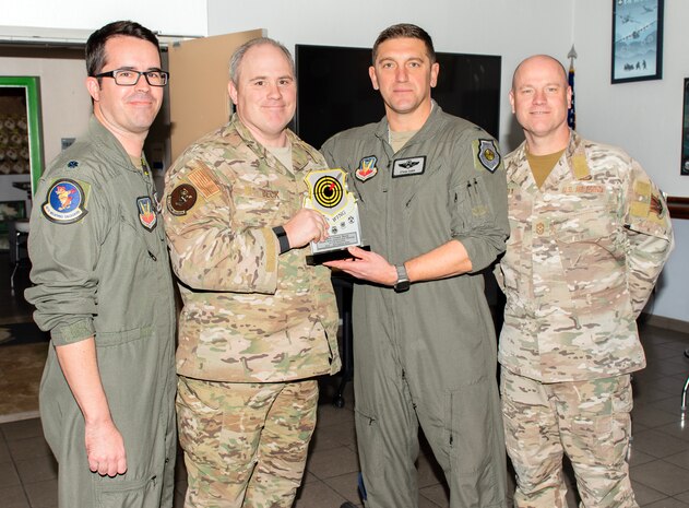 From right, U.S. Air Force Chief Master Sgt. Jason K. Trickey, 57th Wing command chief, and Col. Ethan E. Sabin, 57th Wing commander, present Master Sgt. Chase Beck, a flight chief assigned to the 66th Weapons School, with the Senior Noncommissioned Officer of the Quarter award at Nellis Air Force Base, Nevada, Nov. 20, 2024.