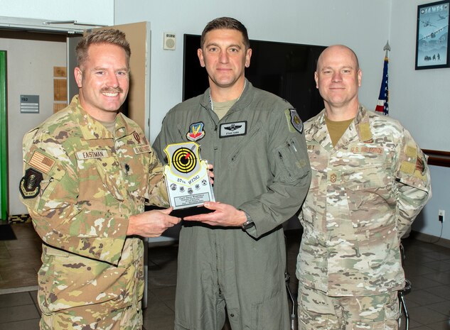 From right, U.S. Air Force Chief Master Sgt. Jason K. Trickey, 57th Wing command chief, and Col. Ethan E. Sabin, 57th Wing deputy commander, present Lt. Col. Seth Eastman, the chief of the command center training branch assigned to the U.S. Air Force Weapons School, with the Company Grade Officer of the Quarter award on behalf of Capt. Dale Warfield, an Air Battle Manager weapons course instructor with the 8th Weapons Squadron, at Nellis Air Force Base, Nevada, Nov. 20, 2024.